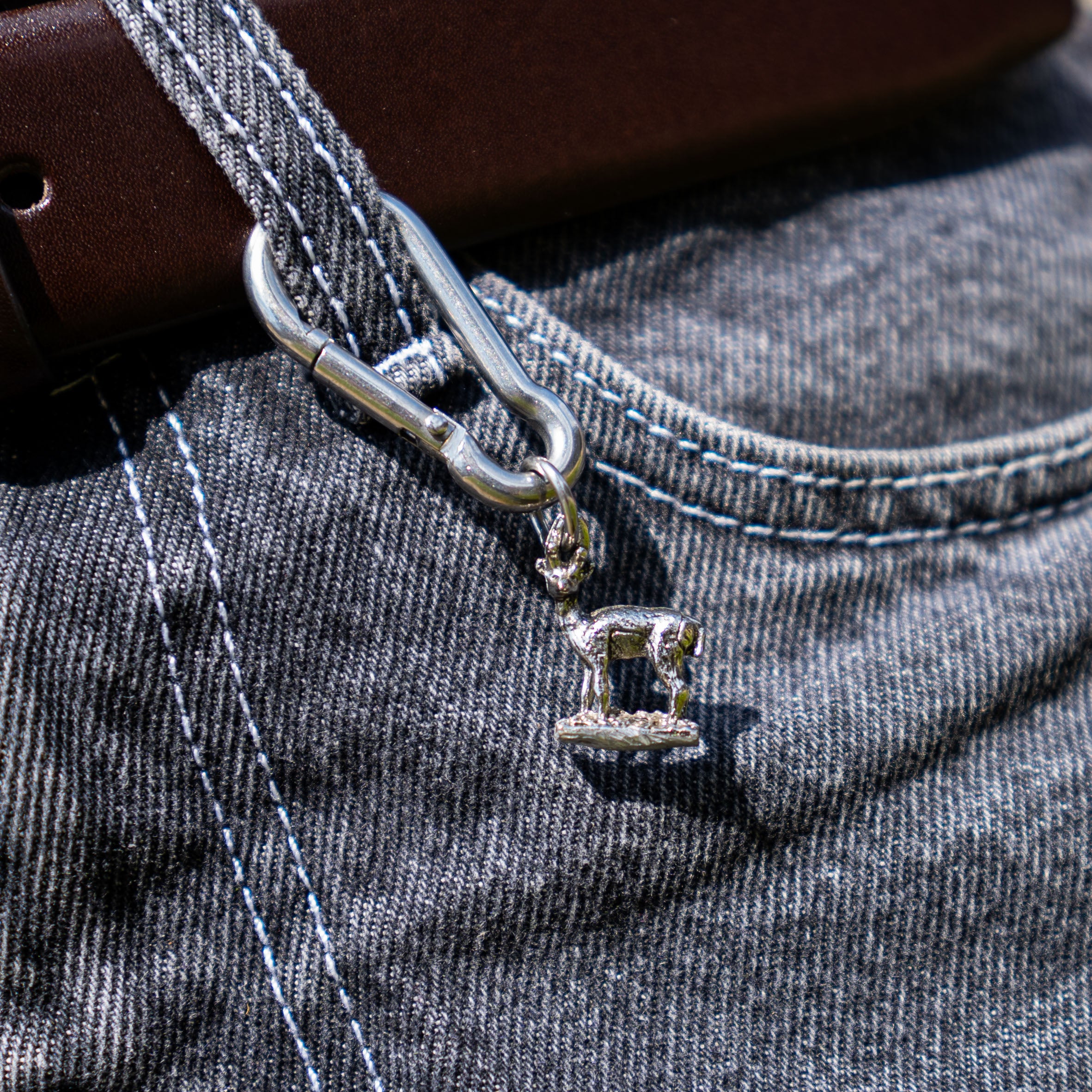 Porte-clés artisanal Gemma en couvert recyclé accroché à un pantalon.