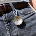 Porte-clés artisanal Gemma en couvert recyclé accroché à un pantalon.