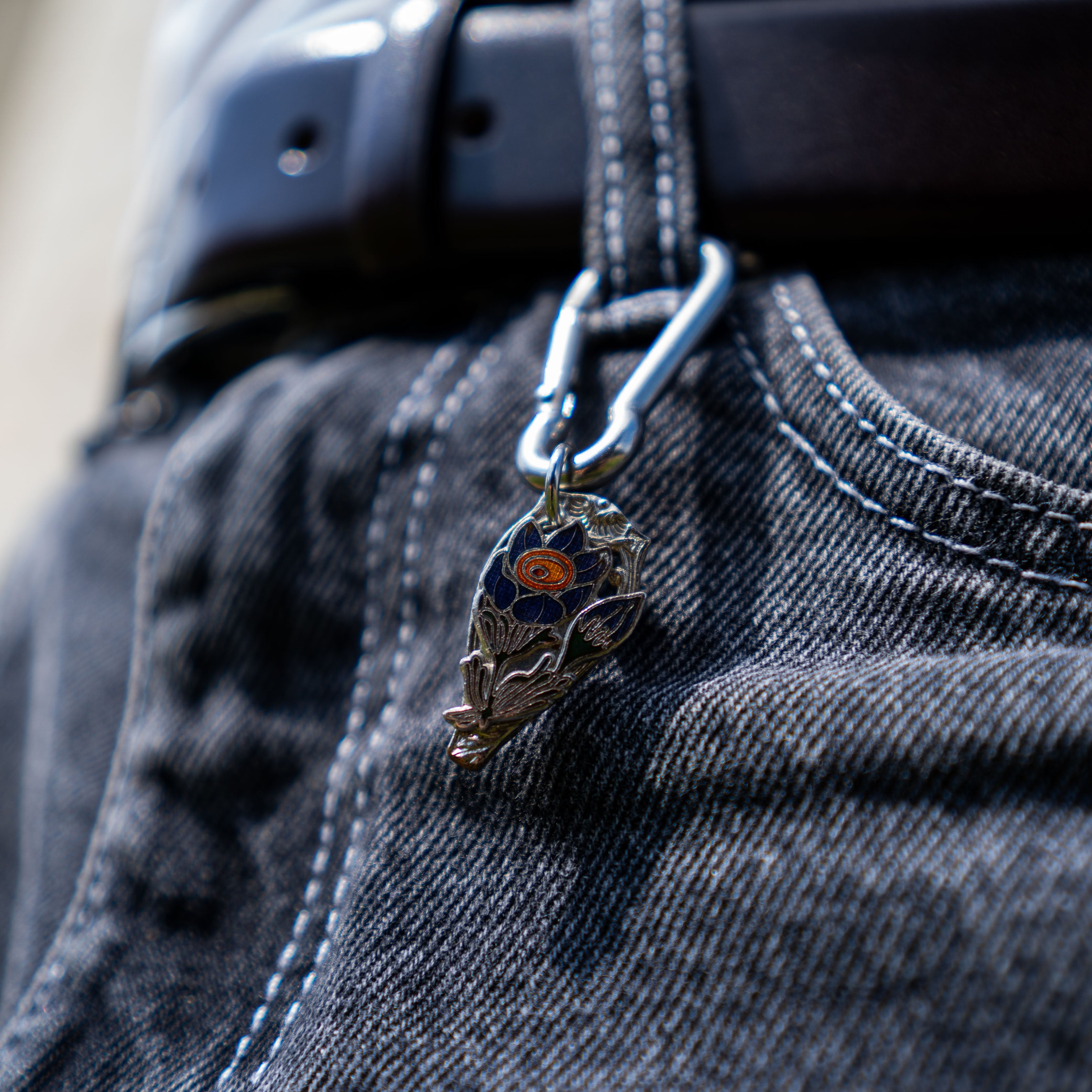 Porte-clés artisanal Gemma en couvert recyclé accroché à un pantalon.