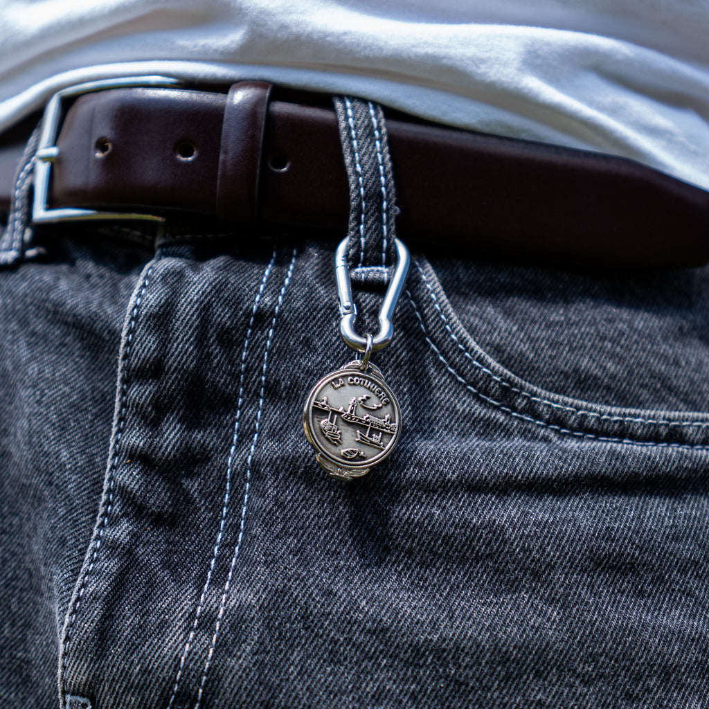 Porte-clés artisanal Gemma en couvert recyclé accroché à un pantalon.