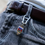 Porte-clés artisanal Gemma en couvert recyclé accroché à un pantalon.