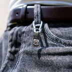 Porte-clés artisanal Gemma en couvert recyclé accroché à un pantalon.