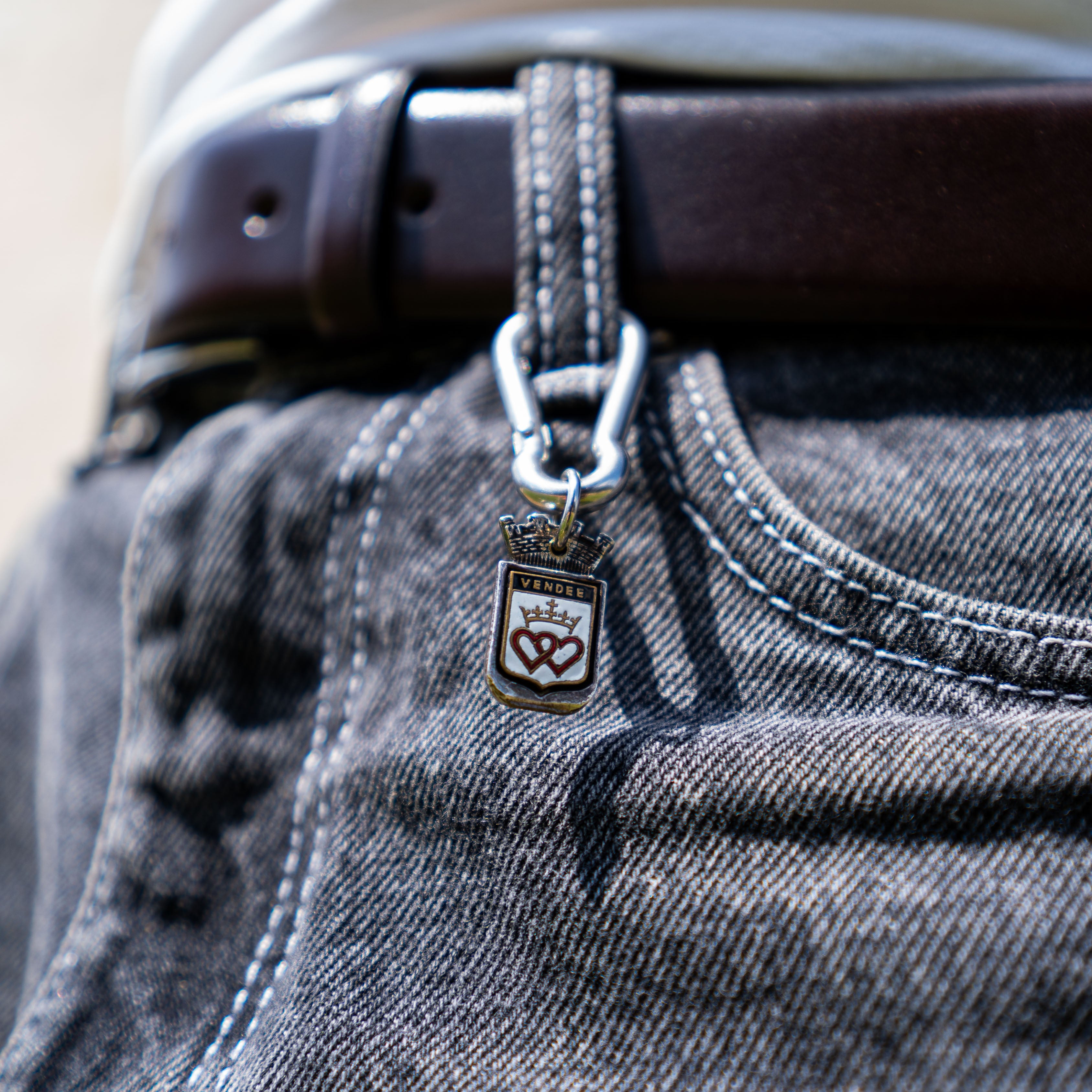 Porte-clés artisanal Gemma en couvert recyclé accroché à un pantalon.