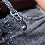 Porte-clés artisanal Gemma en couvert recyclé accroché à un pantalon.