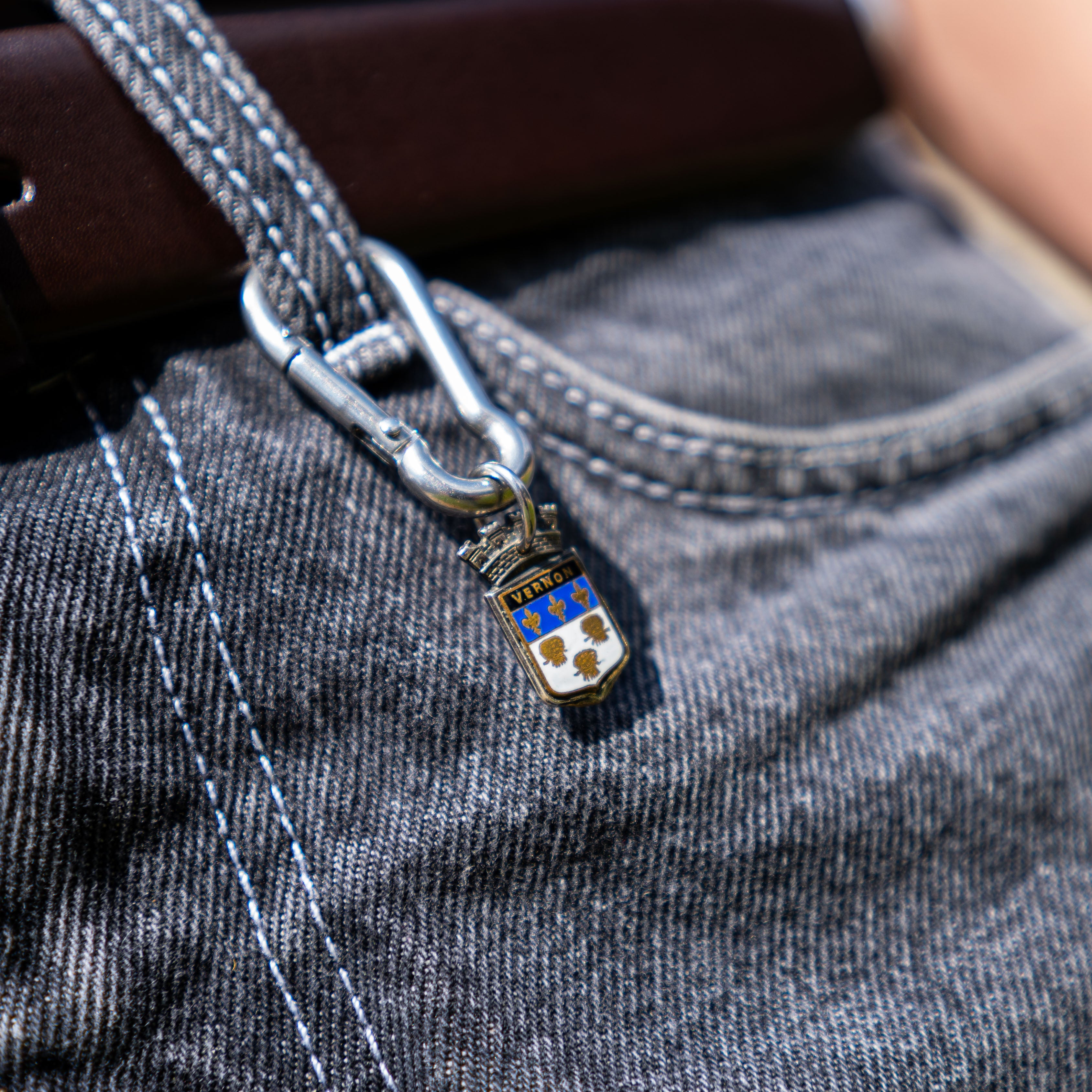 Porte-clés artisanal Gemma en couvert recyclé accroché à un pantalon.